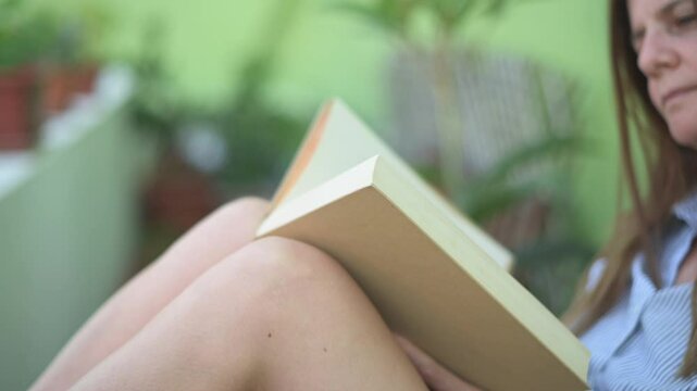 Crop woman reading book in cafe