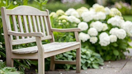 A wooden bench surrounded by lush greenery and white flowers, creating a serene and inviting outdoor space.