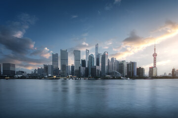 Obraz premium Stunning City Skyline at Sunset Over Water with Reflections