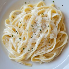 Fettuccine Alfredo with parmesan cheese on white plate