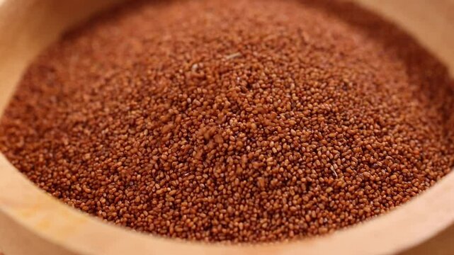Raw teff grain in a wooden bowl close up