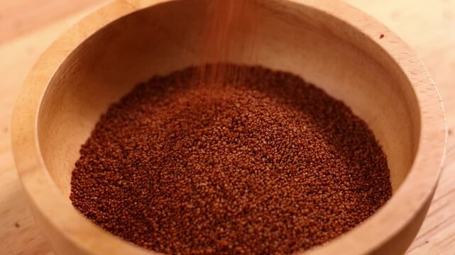 Raw teff grain in a wooden bowl close up