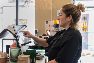 Small business woman using touchscreen at coffee shop