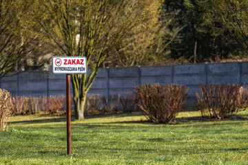 Sign with information about the ban on walking dogs on the lawn, information board,