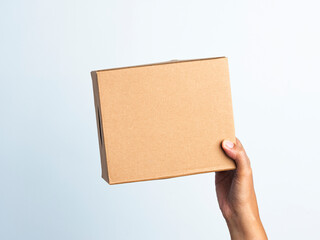 Woman hand hold the brown corrugated box on white background. Young woman hand holding small brown rectangular box on white isolated background.
