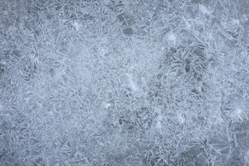 Background texture of shattered ice. Close-up of cracked ice on puddle. Abstract background with copy space for design. Top view
