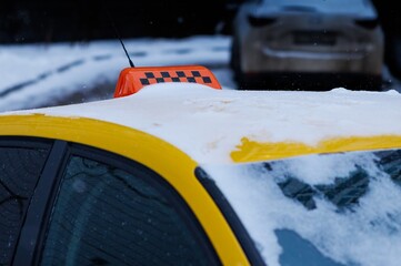 City taxi parked under a gentle snowfall highlighting a winter wonderland ambiance in a quiet urban...
