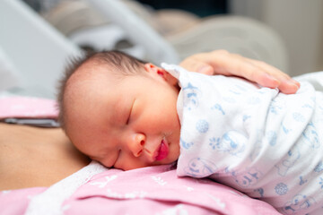 Newborn baby sleeping on mother chest.