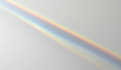 Rainbow light beam reflecting on white wall creating colorful spectrum indoors. Represents serenity and minimalism.