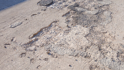 The old badly damaged concrete road background with broken and collapse texture on street surface