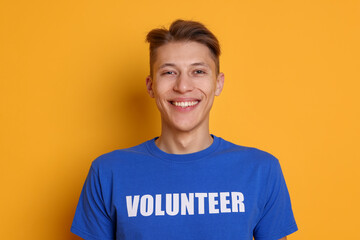 Portrait of smiling volunteer on orange background