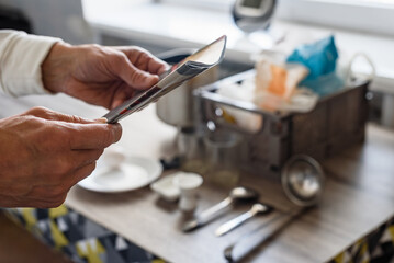 Man reading recipe for making bread dough at home. Bread preparation at home, open recipe book, dough, and baking tools on countertop