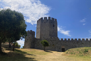 Medieval Greek Platamon castle tower and wall, part of an ancient fortress with historic architecture.Mountain view, sea view, and the Aegean Sea. Nature and history, blue sky, ocean view. 