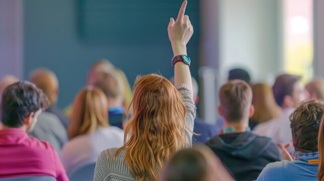 Engaged audience member raises hand during conference presentation session