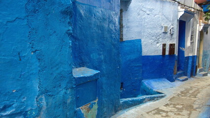 Uneven blue and white walls of an alley in the medina in Chefchaouen, Morocco