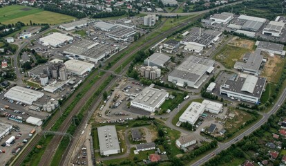 Aerial view of industrial area featuring warehouses, roads, and green fields in Germany, showcasing urban development and economy.