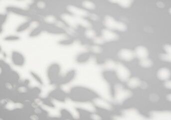 Soft light casts delicate leaf shadows on a gray wall creating a serene monochrome texture. AI Generated