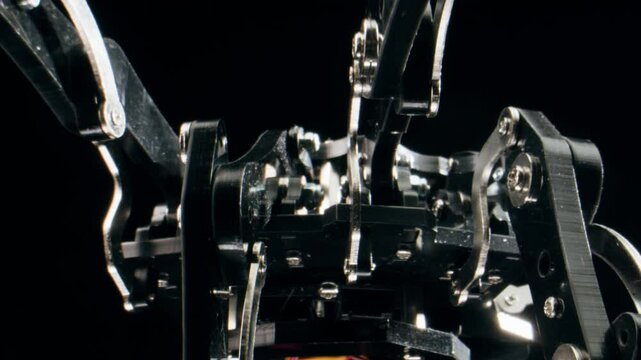 Modern Robotic Arm Holding and Moving, man working with Mechanical components, Engineers Using Tablet Computer to Manipulate and Program the Robot.