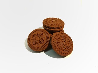 Chocolate biscuits with cream in the middle on a white background.