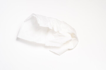 Obraz premium A crumpled piece of white tissue paper, isolated on a white background. Shows the delicate texture and folds of the thin material.