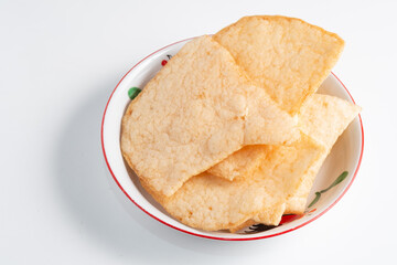 A bowl of Krupuk Udang (prawn crackers), a crispy Indonesian snack.  it's a savory and popular appetizer.