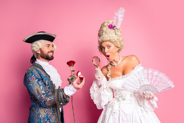 Couple in Vintage Costumes Posing Together in a Retro Style Setting with Pink Background