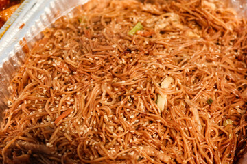 close up of Chinese stir fried noodles in an aluminium foil tray