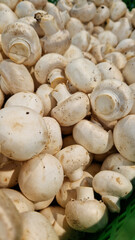 Sale of champignons in a supermarket. Champignons, close-up. Mushrooms in a store. A pile of champignons for sale at the market with selective focus