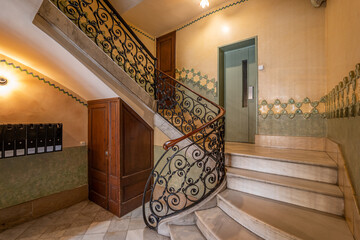 Grand staircase with ornate wrought iron railings and marble steps in an elegant interior