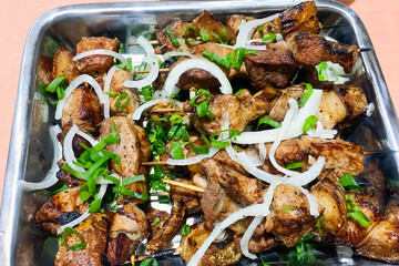 bbq pork shashlik with onions on a metal tray