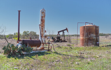Idle, rusty oil well pumping equipment abandoned in field in West Texas.