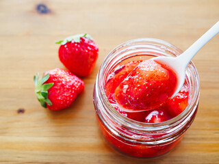 ガラスの器に入れた甘い苺ジャムと新鮮な苺