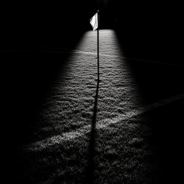 A Lone Flagpost Under a Spotlight: Illuminating the Field's Edge in Black and White