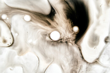 Abstract fluid dynamics of ink merging into creamy tones with rich brown gradients