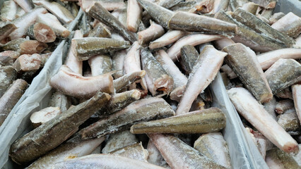 Obraz premium Fish for sale in a store. Frozen fish carcasses in a freezer close-up. Fish store. Fish without head and tail