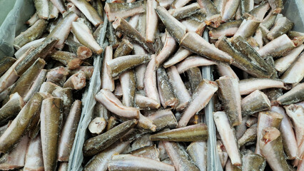 Fish for sale in a store. Frozen fish carcasses in a freezer close-up. Fish store. Fish without head and tail