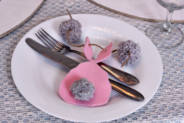 modern Easter table setting with pink felt bunnies on white plates