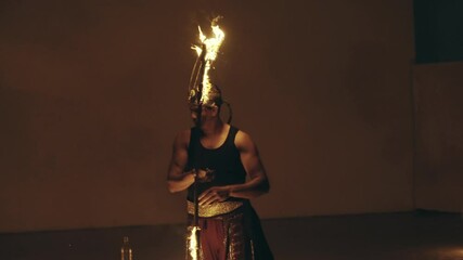 Man skillfully performs an acrobatic fire act, showcasing talent and control, slow motion