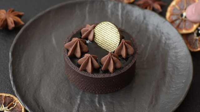 Chocolate tart or dessert with fruit and nuts. Sweet pastries on a dark concrete background