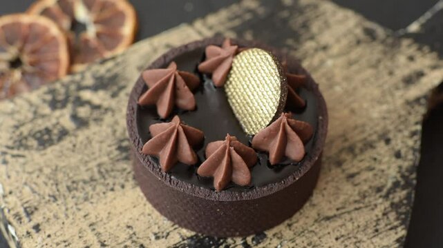 Chocolate tart or dessert with fruit and nuts. Sweet pastries on a dark concrete background