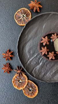 Chocolate tart or dessert with fruit and nuts. Sweet pastries on a dark concrete background