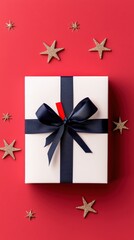 A beautifully wrapped gift box with a navy ribbon on a festive red background.