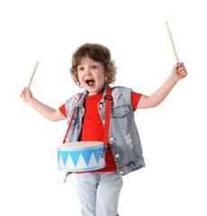 Cute little boy playing toy drum on white background