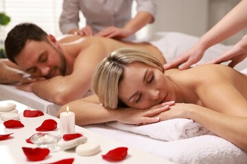Couple receiving relaxing massage in spa salon, selective focus
