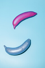 Colorful painted bananas on a blue background showcasing creative art mix