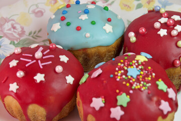sweet Easter bread closeup. homemade muffins, with melted sugar dark red glaze topping, decorated with sprinkles and colored sugar stars