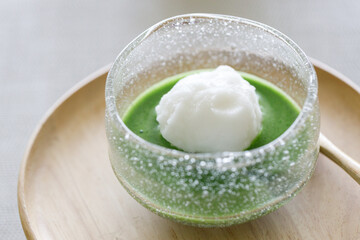 Cup of scoop coconut flavor ice cream and fresh matcha tea, green tea on wooden table.