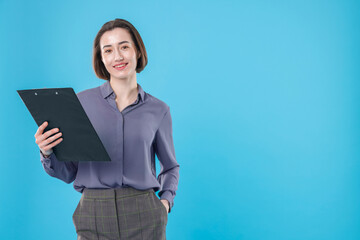 Obraz premium Portrait of smiling secretary with clipboard on light blue background. Space for text