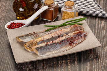 Salted marinated herring fillet with spices