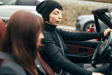Woman drives car red convertible with top down, enjoying open air and sense of freedom. Motion,...